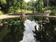 04A Two young boys bicycle past a lily pond in the Sunken Garden in Royal Botanical Hope Gardens Kingston Jamaica